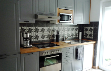 Küche mit Herd, Ofen, Mikrowelle, Spülbecken und Kafeemaschine, Kühlschrank und viele weitere graue Schränke | © Neckar-Zaber-Tourismus e.V.