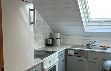 Blick in die Küche der Ferienwohnung mit Ofen, Herd, Kühlschrank und Spüle. | © Neckar-Zaber-Tourismus e.V.