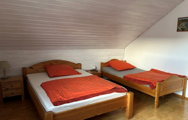 Blick in ein Schlafzimmer mit zwei Betten mit orangener Bettwäsche | © Neckar-Zaber-Tourismus e.V.