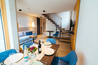 Esstisch mit mindestens 4 Stühlen, eine pastellblaue Couch, Tisch und Stuhl neben der Treppe nach oben | © Neckar-Zaber-Tourismus e.V.