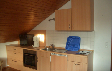Hölzerne Küche mit Ofen, Spüle, und mehreren Schränken und Schubladen | © Neckar-Zaber-Tourismus e.V.