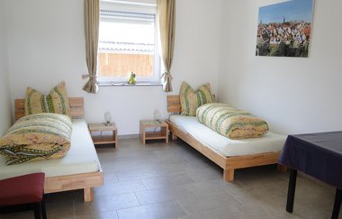 Zimmer mit zwei Einzelbetten, die jeweils einen Nachttisch haben mit Lampe und ein Fenster in der Mitte | © Neckar-Zaber-Tourismus e.V.