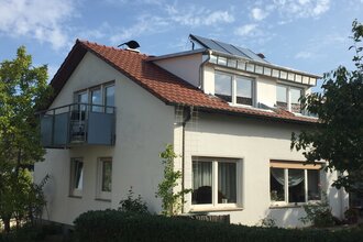 Ein weißes Haus mit Balkon und Garten. | © Ilse Hofmann