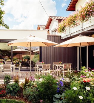 Frühstücksterrasse mit vielen Tischen und Stühlen und Schirmen | © Landpension Kohler