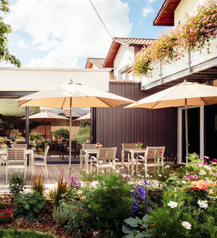 Frühstücksterrasse mit vielen Tischen und Stühlen und Schirmen | © Landpension Kohler