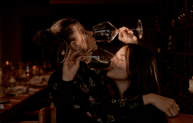 Zwei Frauen die aus Weingläsern trinken | © Dominik Cini