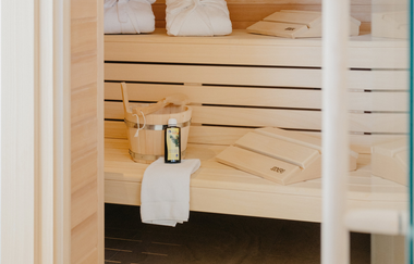 Blick in eine moderne finnische Sauna mit hellem Holz und zwei gestufte Liege- bzw. Sitzbereiche. | © Weingut Becker, Malsch