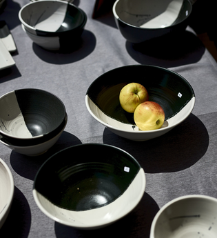 Schwarz-Weiße Schalen stehen auf einem Tisch. In einer Schale befinden sich zwei Äpfel. | © Touristikgemeinschaft Hohenlohe e.V. | Stefan Leitner