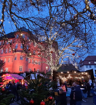 Blick auf den festlich geschmückten Weihnachtsmarkt in Künzelsau mit Schloss Bartenau im Hintergrund | © Touristikgemeinschaft Hohenlohe e.V. | Stadtverwaltung Künzelsau
