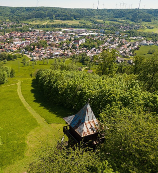 Luftbildaufnahme - Blick über Kernerturm den Berghang hinunter auf Gaildorf, im Hintergrund auf der anderen Talseite die bewaldeten Limpurger Berge mit zahlreichen Windrädern | © Stadt Gaildorf