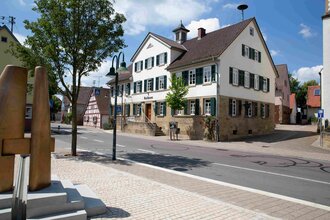 Außenansicht eines historischen Dorfhauses mit einer Dorfstraße im Vordergrund. | © Stadt Brackenheim