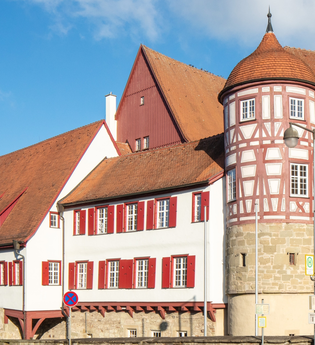 altes Schloss - rechts das Torhaus mit Sockelgeschoss aus hellem Sandstein und aufgesetztem roten Fachwerk mit weißen Gefachen, flankiert von zwei Rundtürmen. In der Bildmitte der Westflügel mit zwei aneinandergebauten, weiß verputzten Gebäudeteilen mit r | © Stadt Gaildorf