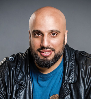 Porträt eines Mannes mit Glatze und Bart in Lederjacke vor grauem Hintergrund. | © Konzertkreis Triangel Compagnia Compostelli e.V.