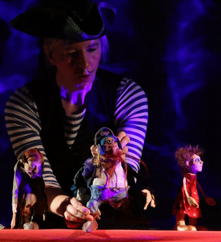 Schauspieler im kapitänskostüm mit Spielfiguren