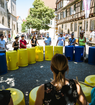 Gruppe von Musikern, die auf Tonnen trommeln