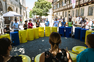 Gruppe von Musikern, die auf Tonnen trommeln
