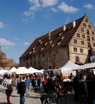Belebter Kunsthandwerkermarkt mit Zelten und Besuchern vor den historischen Gebäuden des Klosters Maulbronn | © Stadt Maulbronn