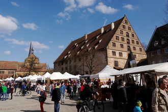 Belebter Kunsthandwerkermarkt mit Zelten und Besuchern vor den historischen Gebäuden des Klosters Maulbronn | © Stadt Maulbronn