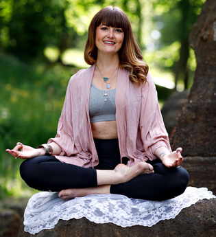Sonja Lanig sitzt in einer Yoga-Pose im Garten | © Sonja Lanig