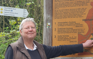 Der Stadtführer zeigt auf die Wandertafel im Exotenwald | © Dietmar Spicker