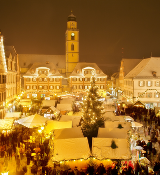 Weihnachtsmarktstände auf dem Markplatz. Der Platz ist mit Lichterketten beleuchtet. | © Stadt Bad Mergentheim