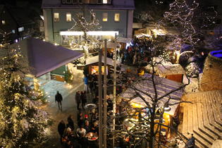 In weihnachtlicher Lichteratmosphäre stehen viele Besucher auf einem Marktplatz und sprechen miteinander. | © Gemeinde Blaufelden