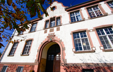 Historisches weißes Schulgebäude mit Rundbogen als Eingang und großen Fenstern | © Gemeinde Epfenbach