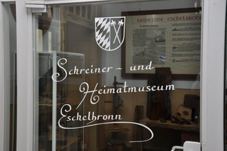Weißer Schriftzug Schreiner- und Heimatmuseum auf Glas