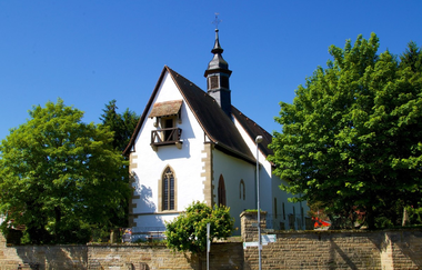 Kleine weiße Kirche mit Turm umgeben von einer Steinmauer und Bäumen | © Stadt Neckarbisachofsheim