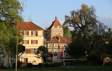Turm aus Fachwerk mit rotem Dach und angrenzendem gelben Gebäude | © Stadt Neckarbischofsheim
