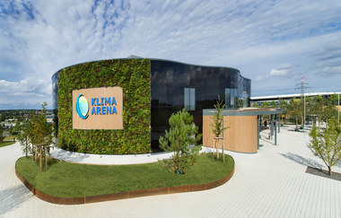 Bewachsenes Gebäude der Klima Arena vor bewachsenem Pflanzenbeet | © Klima Arena