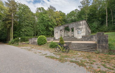 Steinernes Grabmal mit Treppenaufgang im Wald