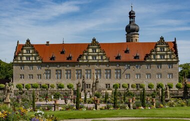 Blick auf das Schloss Weikersheim, mit dem Schlossgarten im Vordergrund.