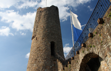 Turm der Burgruine Windeck mit Beflaggung vor strahlend blauem Himmel. | © Maria Zimmermann