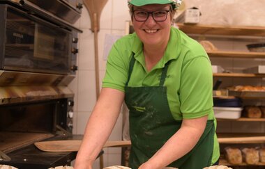 Frau richtet Brotlaibe in der Backstube | © Landratsamt Karlsruhe