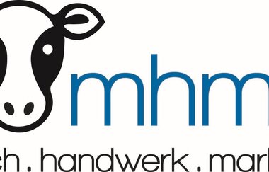 Das Logo ist ein schwarzweißer Kuhkopf mit Schriftzug mhm.... milch.handwerk.marlach. | © Touristikgemeinschaft Hohenlohe e. V. | Milchhandwerk Marlach