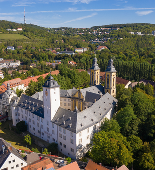Luftaufnahme vom Residenzschloss Mergentheim. Man sieht den Schlosshof mit den Kirchtürmen, der Schlosspark im Hintergrund | © Björn Hänssler