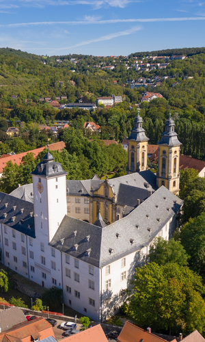 Luftaufnahme vom Residenzschloss Mergentheim. Man sieht den Schlosshof mit den Kirchtürmen, der Schlosspark im Hintergrund | © Björn Hänssler