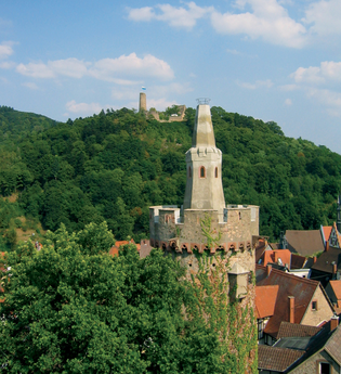 Roter Turm im Vordergrund und im Hintergrund die Burgruine Windeck auf dem grünen Berg.