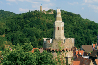 Roter Turm im Vordergrund und im Hintergrund die Burgruine Windeck auf dem grünen Berg.