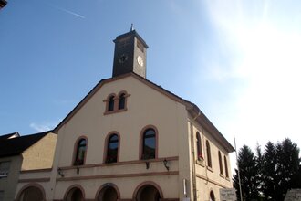 Gebäude mit Glockenturm vor blauem Himmel | © Maria Zimmermann
