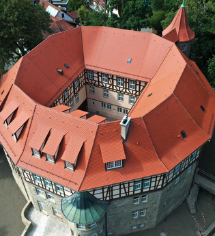 Luftaufnahme des historischen Wasserschlosses in Sachsenheim, umgeben von Bäumen und malerischer Natur. | © Stadt Sachsenheim