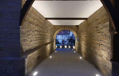 Stimmungsvoll beleuchteter Durchgang im historischen Wasserschloss Sachsenheim. | © Stadt Sachsenheim