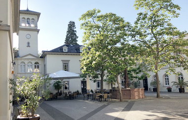 Ein schöner Innenhof mit Bäumen und Sitzmöglichkeiten von Gebäuden umgeben. | © Bettina Gessinger