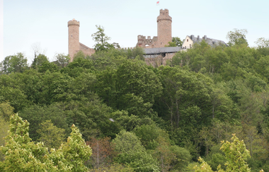 Ein Schloss im Wald vor blauem Himmel. | © Bettina Gessinger
