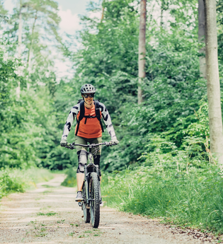 Eine Mountainbikerin fährt mit ihrem Bike durch einen Wald | © Touristikgemeinschaft Odenwald e.V.