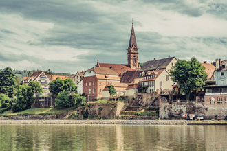 Blick auf die historische Altstadt mit Kirchturm von Neckargemünd, im Vordergrund fließt der Neckar | © Touristikgemeinschaft Odenwald e.V.