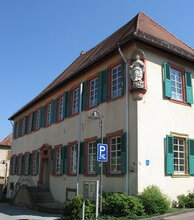Historisches Gebäude mit weißen Sprossenfenstern und grünen Fensterläden an einem klaren Sommertag | © Stadt Sinsheim