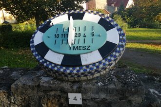 Blick auf eine in blau und weiß gehaltene Sonnenuhr der Stadt Röttingen. | © Liebliches Taubertal