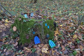 Wichtelstation Haus mit Wichteltüren an einem bemoosten Baumstumpf im Wald | © Frau Leist